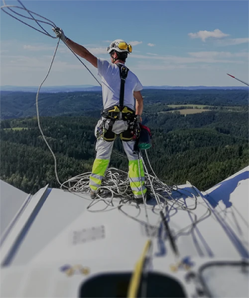 Lone worker working with helmet and protective equipment at a height on a wind turbine