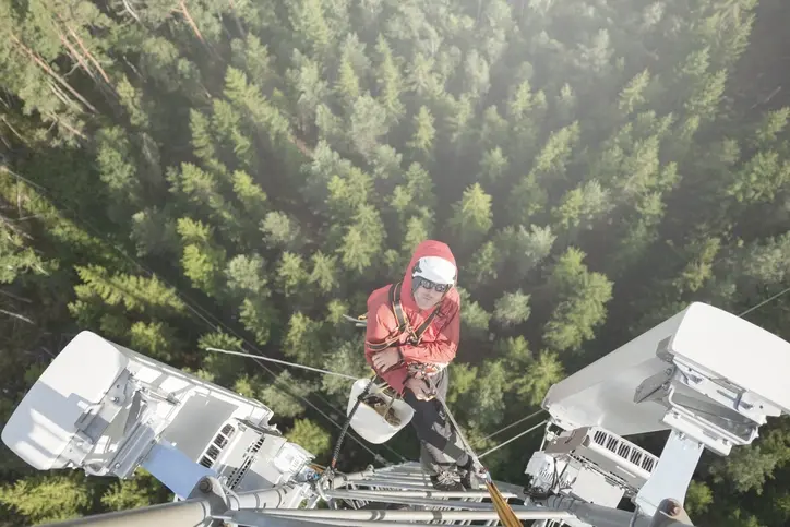 Male working at height with protective gear in a remote and rural area