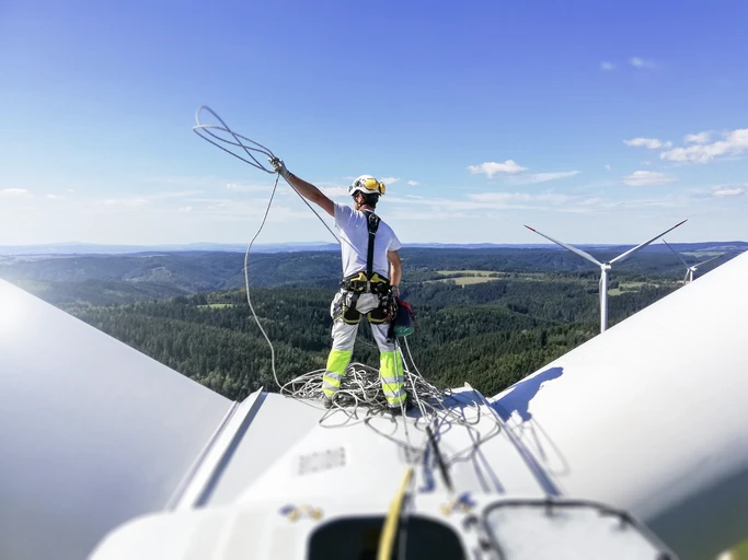 Lone worker working with helmet and protective equipment at a height on a wind turbine